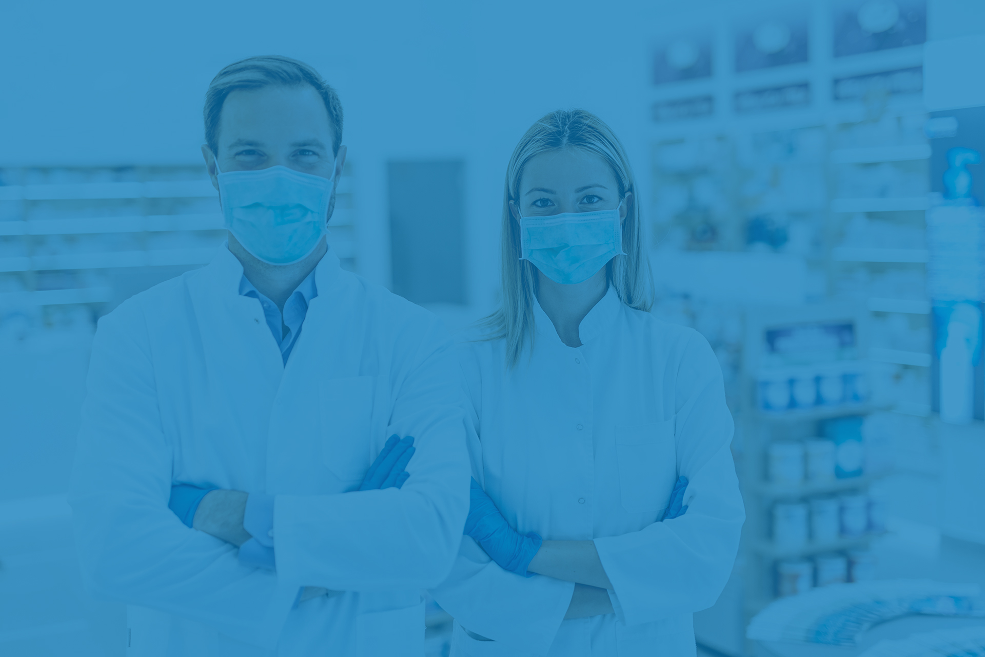 Pharmacists posing in front of rows of medication