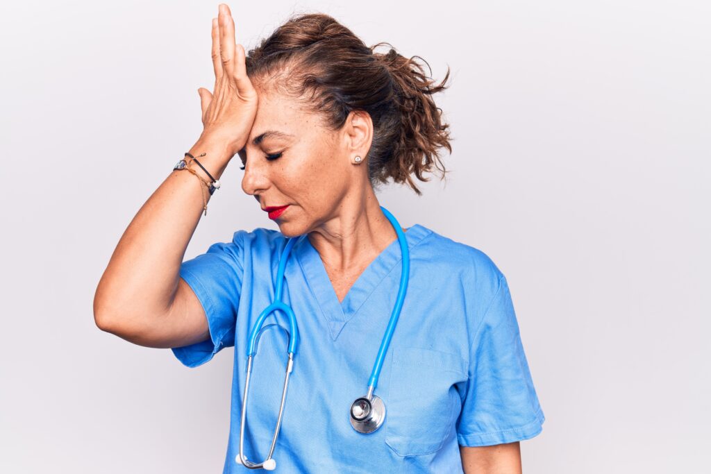 Frustrated nurse with palm on forehead